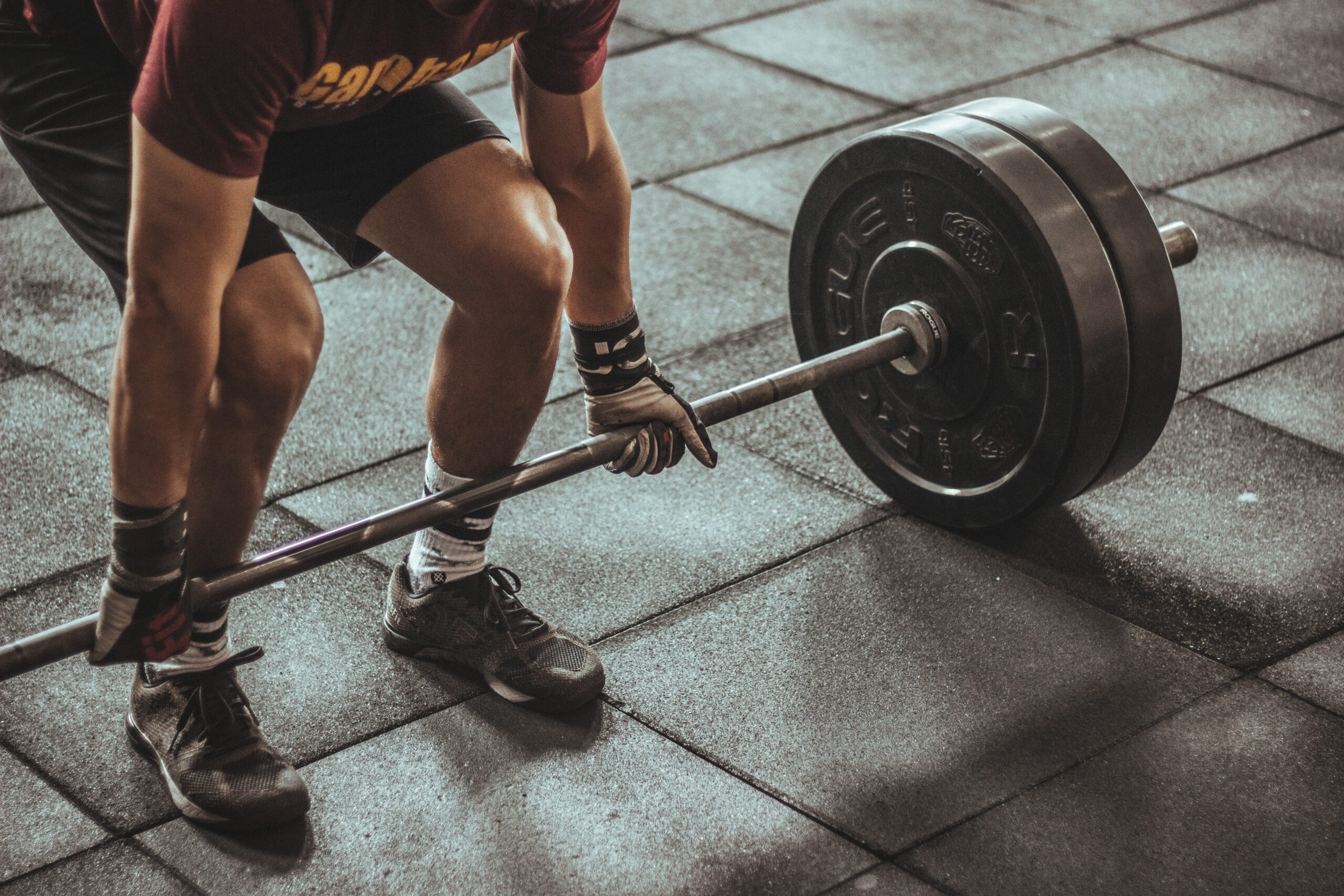 Beginner practicing strength training with free weights in a gym